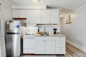 a kitchen with white cabinets and a stainless steel refrigerator at Sea La Vie in Edisto Island