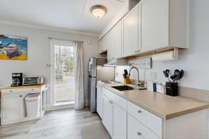 a kitchen with white cabinets and a refrigerator at Sea La Vie in Edisto Island +7 photos