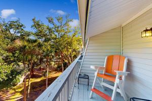 an orange and white chair sitting on a porch at Driftwood Villa - 267 in Edisto Island