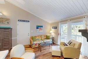 a living room with a couch and a chair at Driftwood Villa - 267 in Edisto Island