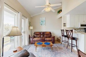 a living room with a leather couch and a table at Driftwood Villa - 287 in Edisto Beach