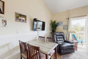 a living room with a table and a chair at Driftwood Villa - 287 in Edisto Beach
