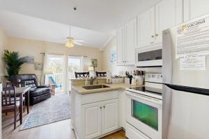 a kitchen with white appliances and a dining room at Driftwood Villa - 287 in Edisto Beach +12 photos