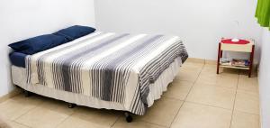 a bed with a striped blanket in a room at Sítio Topo do Vale in Sabará +54 photos