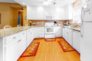 a kitchen with white appliances and a wooden floor at Morillo's Miracle in Edisto Beach