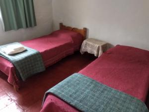 two beds in a room with red and green blankets at nisueñes in Belén de Escobar +7 photos
