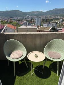 two chairs and tables on a balcony with a view at Apartment Lunette in Mostar