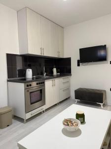 a kitchen with white cabinets and a white table at Apartment Lunette in Mostar