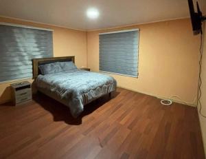 a bedroom with a bed and two windows at Hospedaje marylin in La Serena