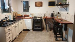 a kitchen with white cabinets and a black stove at Quinta La llama violeta in Campana