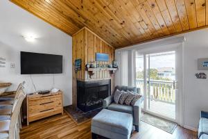 a living room with a chair and a fireplace at Driftwood Villa - 259 in Edisto Beach