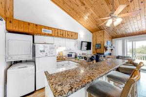 a kitchen with white appliances and a ceiling fan at Driftwood Villa - 259 in Edisto Beach +8 photos