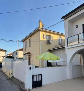 a yellow umbrella on the side of a house at Casa cidade e piscina in Coimbra
