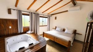 a room with a bath tub and a bed at Pousada Verde Serena SFX in São Francisco Xavier