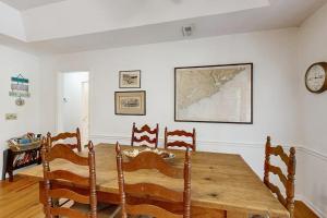 a dining room with a table and chairs and a clock at Cupid's Nest in Edisto Beach +17 photos