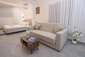 a living room with a couch and a table at פלואלס - וילת יוקרה עם 4 חדרי שינה ובריכה מחוממת וגקוזי in Shahar +53 photos