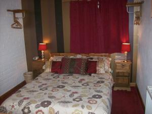 1 dormitorio con 1 cama y 2 mesitas de noche con lámparas en Fairholme en Dartmouth