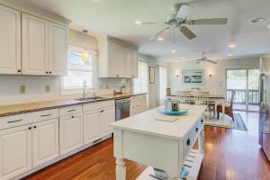 a kitchen with white cabinets and a ceiling fan at Goldie's Retreat in Edisto Beach +27 photos