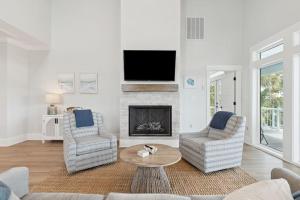 a living room with two chairs and a fireplace at Champagne and Sunsets in Edisto Island