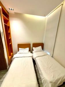 two beds sitting in a small room with at شاليهات سمو بارك in Taif