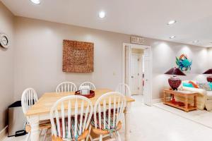 a dining room with a wooden table and white chairs at Slow Drift in Edisto Beach +29 photos