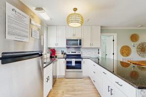 a kitchen with white cabinets and a counter top at Heaven on Harrelson in Edisto Beach +19 photos