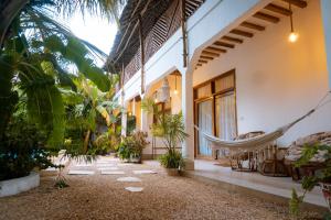 a hammock hanging from the side of a house at Jaje Paje Villa in Paje