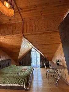 a room with a bed and a table in a attic at Shine Hill შაინ ჰილი in Tsinsvla