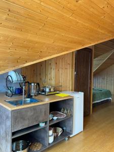 a kitchen with wooden walls and a wooden ceiling at Shine Hill შაინ ჰილი in Tsinsvla