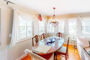 a dining room with a glass table and chairs at Pink Bird Cottage in Edisto Beach