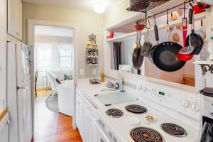 a white kitchen with a stove and a sink at Pink Bird Cottage in Edisto Beach