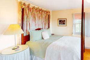 a bedroom with a bed and a table with a lamp at Pink Bird Cottage in Edisto Beach