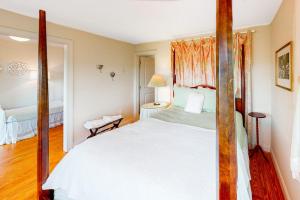 a bedroom with a white bed and a mirror at Pink Bird Cottage in Edisto Beach