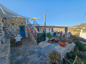 a stone house with a blue door and some plants at Aspalathos I & ΙΙ in Kamárion