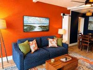 a blue couch in a living room with an orange wall at Renovated Oceanfront 1BR by Skywheel Yachtsman 400 in Myrtle Beach