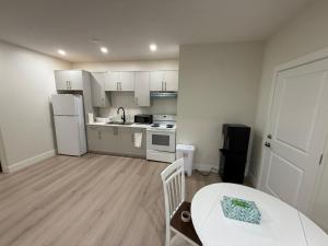 a kitchen with a table and a white refrigerator at 2 Bedrooms Private EntRance wifi Free Parking in Prince George