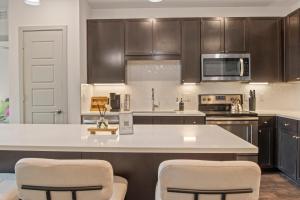 a kitchen with a white counter top and brown cabinets at Walk to Toyota Stadium in Frisco