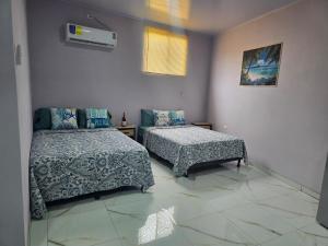 a bedroom with two beds and a couch in it at Apartamentos Torres Manuel Antonio in Manuel Antonio