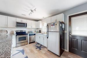 a kitchen with white cabinets and stainless steel appliances at Hamptons South in Edisto Beach