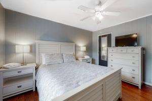 a bedroom with a white bed and a ceiling fan at Hamptons South in Edisto Beach