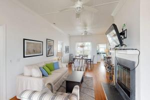 a living room with a couch and a flat screen tv at Myra's Cottage in Edisto Beach
