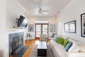 a living room with a white couch and a fireplace at Myra's Cottage in Edisto Beach