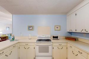 a kitchen with white cabinets and a stove top oven at Sand Quarters in Edisto Beach