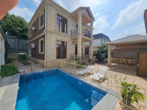 a house with a swimming pool in front of a house at Riverside Villa GDR in Gabala