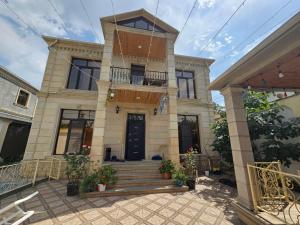 a large house with a staircase in front of it at Riverside Villa GDR in Gabala
