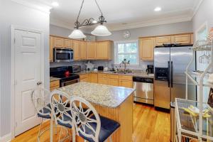 a kitchen with wooden cabinets and stainless steel appliances at Chateau Relaxo in Edisto Beach
