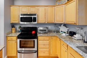 a kitchen with wooden cabinets and a stove top oven at Chateau Relaxo in Edisto Beach