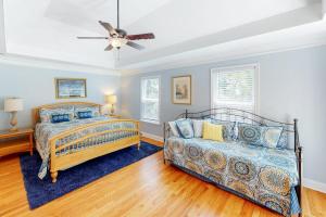 a bedroom with two beds and a ceiling fan at Chateau Relaxo in Edisto Beach