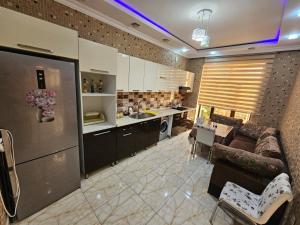 a kitchen and a living room with a couch and a table at Riverside Villa GDR in Gabala