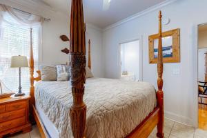 a bedroom with a four poster bed and a window at Stare-Gazing in Edisto Beach